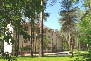 una vista esterna di un edificio con alberi in primo piano di MOROZOVO Resort-Hotel&SPA a Berdsk