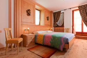 1 dormitorio con cama, escritorio y silla en Appartamenti Royal, en San Vito di Cadore