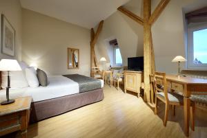 een hotelkamer met een bed, een bureau en een bureau bij Eurostars Park Hotel Maximilian in Regensburg