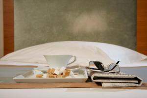 a tray with a cup and a plate of food and glasses at Rodos Park in Rhodes Town
