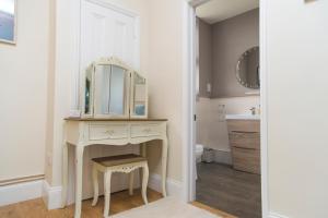 a bathroom with a dressing table and a mirror at The Lodge at Heathfield in Ledbury