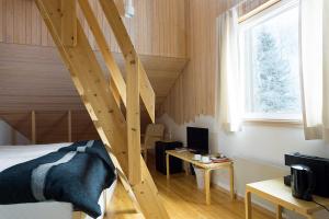 a bedroom with a bed and a wooden staircase at Hotel Vartiosaari The Aurora Island in Rovaniemi