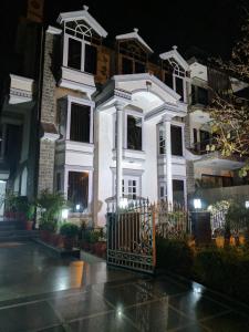 Biały dom z bramą przed nim w obiekcie Hotel Windsor Castle Cyber City w mieście Gurgaon