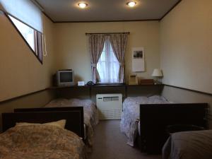 a bedroom with two beds and a window at Shikino Yado Subaru in Chino