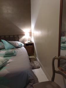 ein Schlafzimmer mit einem Bett und einem Tisch mit einer Lampe in der Unterkunft Lougat la maison des chats in Cordes-sur-Ciel