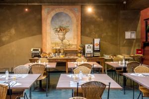 a dining room with tables and chairs and a painting on the wall at Arass Hôtel & Business Flats in Antwerp
