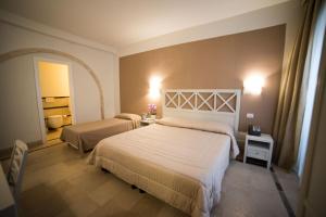 a hotel room with two beds and a mirror at Hotel Gargallo in Siracusa