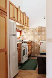 a kitchen with a white refrigerator and wooden cabinets at Casa "da Paola" in San Vito lo Capo