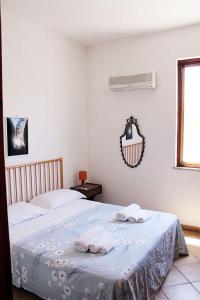 una camera da letto con un letto e asciugamani di Casa "da Paola" a San Vito lo Capo
