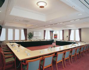 een grote vergaderzaal met een lange tafel en stoelen bij Hotel Dekkers in Ossendrecht