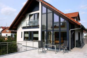 uma casa com janelas de vidro e um telhado em Ferienhaus Bauerngarten em Bad Buchau