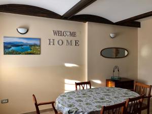 ein Esszimmer mit einem Tisch und Stühlen und ein Schild, auf dem sich das Willkommenshaus zeigt in der Unterkunft Bled Home in Bled