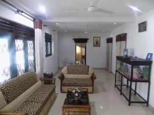 een woonkamer met 2 banken en een aquarium bij Alexandra Family Villa in Negombo