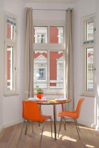 a dining room with a table and chairs and a window at Düsselapp in Düsseldorf