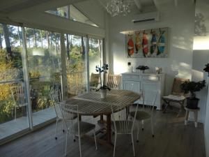 uma sala de jantar com mesa e cadeiras em une maison lumineuse sous les pins em Le Canon