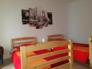 um quarto com 2 beliches e lençóis vermelhos em Lagos City Center Guest House & Hostel em Lagos