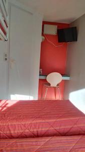 モアランにあるPremiere Classe Grenoble Nord Moiransの赤いベッドルーム(ベッド1台、椅子付)