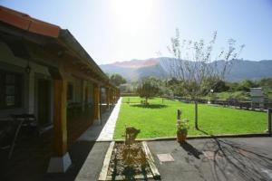 a view of a building with a field and mountains in the background at Apartamentos Picu Castiellu in La Galguera