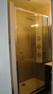 La salle de bains est pourvue d'une douche avec une porte en verre. dans l'établissement residence arromanche, à Vannes
