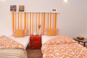 2 Betten in einem Zimmer mit orangefarbener und gelber Bettwäsche in der Unterkunft Düsselapp in Düsseldorf