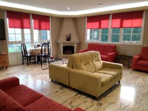 a living room with a couch and chairs and a fireplace at Hotel Castro in Santiago de Compostela