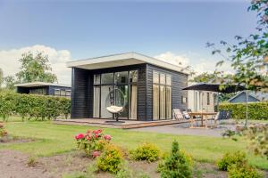 a tiny house with a garden and a patio at Buitenplaats Holten in Rijssen