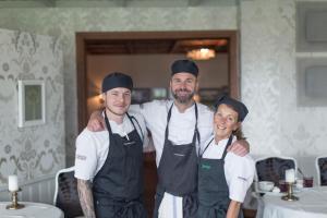 un grupo de tres chefs parados unos con los brazos alrededor del otro en Hestraviken Hotell & Restaurang en Hestra