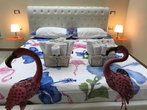 dwóch flamingów stojących na łóżku w sypialni w obiekcie Flamingo Luxury Apartment AJPSARDINIA w Cagliari