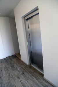 a metal elevator in a room with a tile floor at Donati Business Rooms in Subbiano