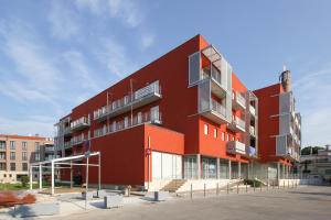 - un bâtiment rouge avec des balcons sur le côté dans l'établissement Apartment Sunset Colours, à Umag