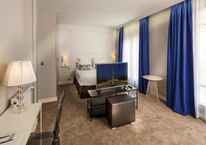 a hotel room with a bedroom with a bed and a television at Hôtel Paris Vaugirard in Paris