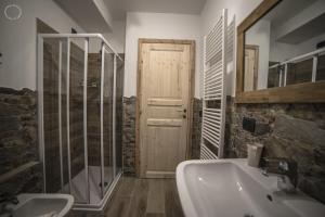 阿普里卡的住宿－B & B Le Riue，一间带水槽和淋浴的浴室以及一扇门