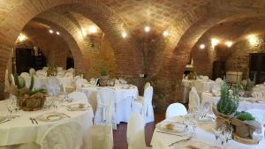 Il Convento di Monte Pozzali في ماسا ماريتيما: غرفة طعام مع طاولات بيضاء وكراسي بيضاء