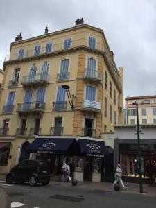 ein Gebäude auf einer Straße mit Leuten, die davor laufen in der Unterkunft AGENCIA apartement 3 PIECES RUE D'ANTIBES in Cannes