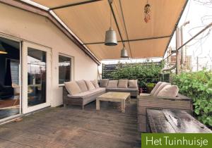 un patio con sofás y una mesa en una terraza en Garden House, Private studio apartment with wifi and free parking for 1 car, en Weesp