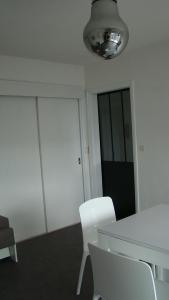 un bureau avec une table et des chaises blanches dans l'établissement residence arromanche, à Vannes