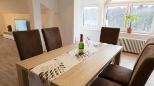 ein Esszimmer mit einer Flasche Wein auf dem Tisch in der Unterkunft Ferienwohnung Rennsteigblick in Tambach-Dietharz