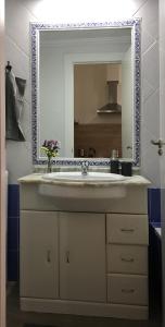 een badkamer met een wastafel en een spiegel bij Apartment Muñoz 1 in Alicante