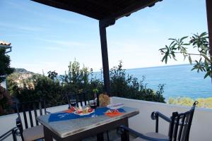a table on the balcony with a view of the ocean at Pelion Orama in Agios Ioannis Pelio