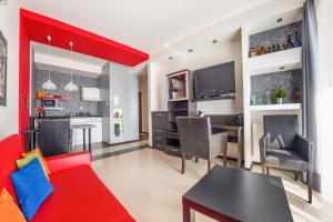 a living room with a red couch and a table at Apartamenty Sun & Snow Lisi Jar in Jastrzębia Góra