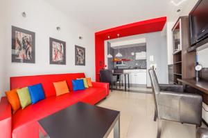 a living room with a red couch and a table at Apartamenty Sun & Snow Lisi Jar in Jastrzębia Góra