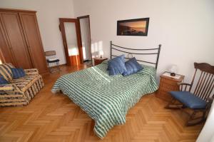 um quarto com uma cama com almofadas azuis e uma cadeira em Glicine apartment em Levanto