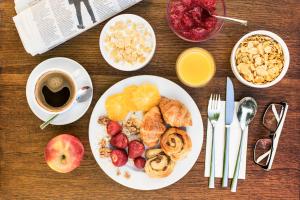 a table with a plate of breakfast foods and a cup of coffee at Abella Suites & Apartments by Artery Hotels in Krakow