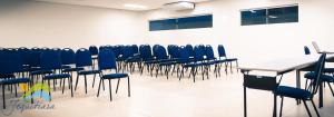 a conference room with blue chairs and a table at Jequitiara Hotel in Itaobim