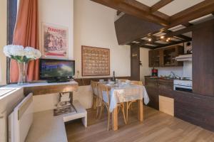 una cucina e una sala da pranzo con tavolo e cucina di Résidence Grand Roc - Campanules 415 - Happy Rentals a Chamonix-Mont-Blanc