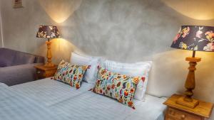 Un dormitorio con una cama con almohadas y dos lámparas. en Windmill Studios by Rembrandt Old Town, en Bucarest