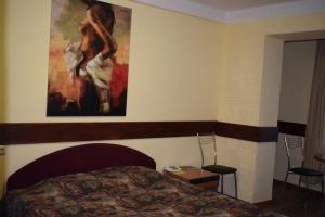 1 dormitorio con 1 cama y una pintura en la pared en Hotel Desna KUT en Kiev