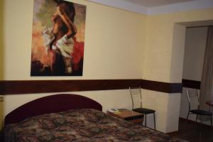キーウにあるホテル デスナ KUTのベッドルーム1室(ベッド1台付)が備わります。壁には絵画が飾られています。