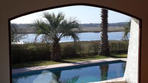 ventana con vistas a la piscina y a las palmeras en Waslala, en Punta del Este