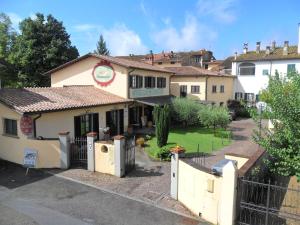 a building with a fence in front of a yard at Donati Business Rooms in Subbiano